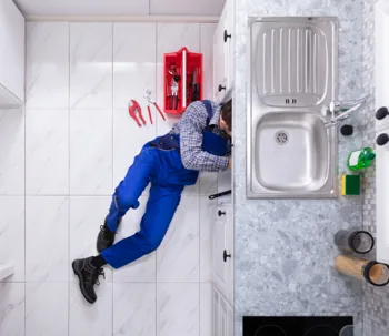 plumber working under the sink