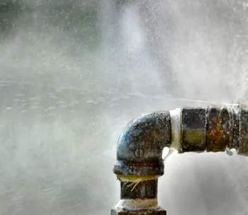 Leaking metal pipe spraying water under high pressure.