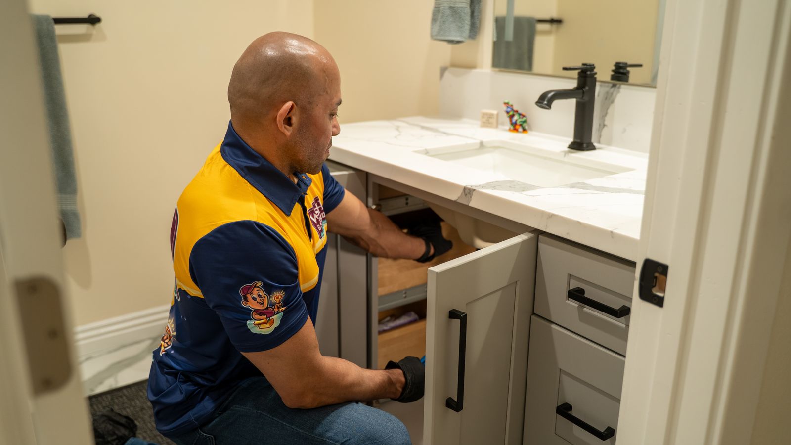 Wish Granted Plumbing technician inspecting the plumbing under a sink.