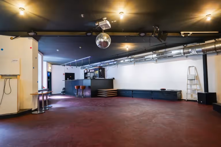 Foto des Veranstaltungsraums ohne Bestuhlung, im Hintergrund sieht man die Bartheke