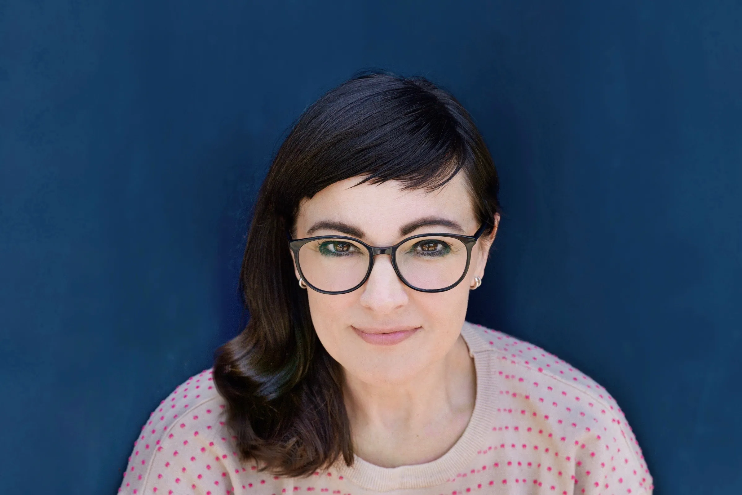 Frau mit Brille und dunkelbraunem schulterlangem Haar