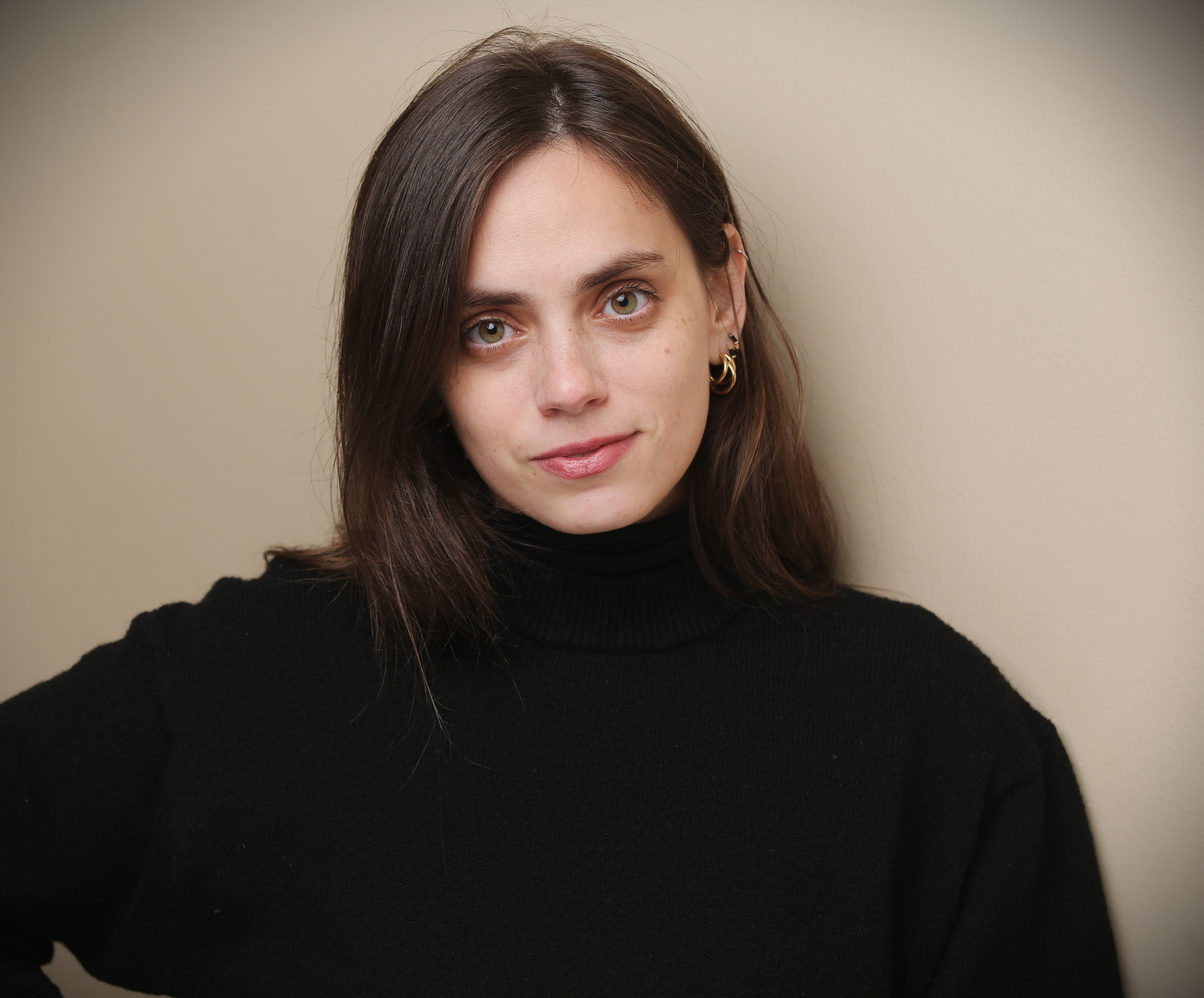 Junge Frau mit glatten braunen Haaren und schwarzem Rollkragenpullover