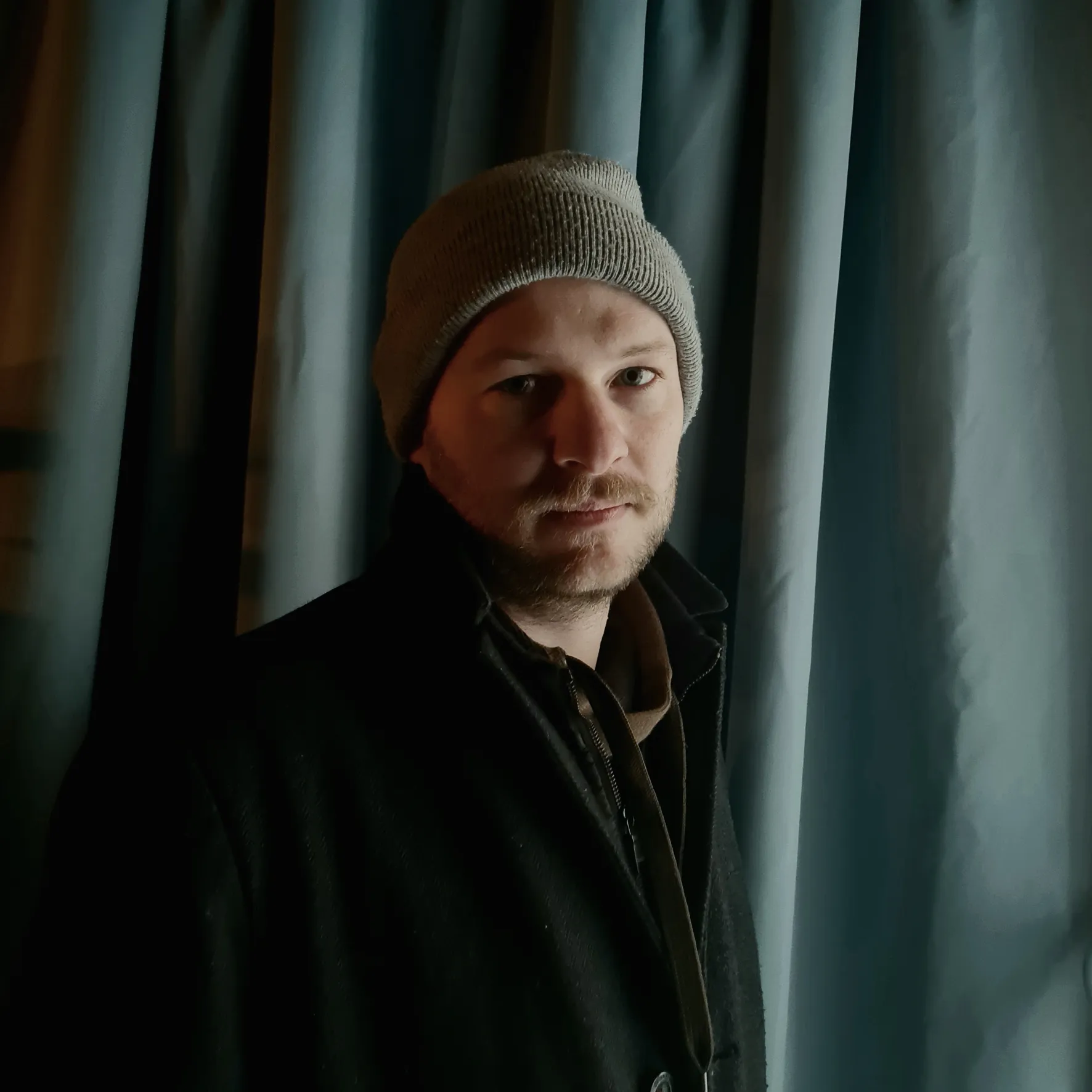Porträtfoto von Alexander Rudolfi in grauer Mütze und schwarzer Jacke