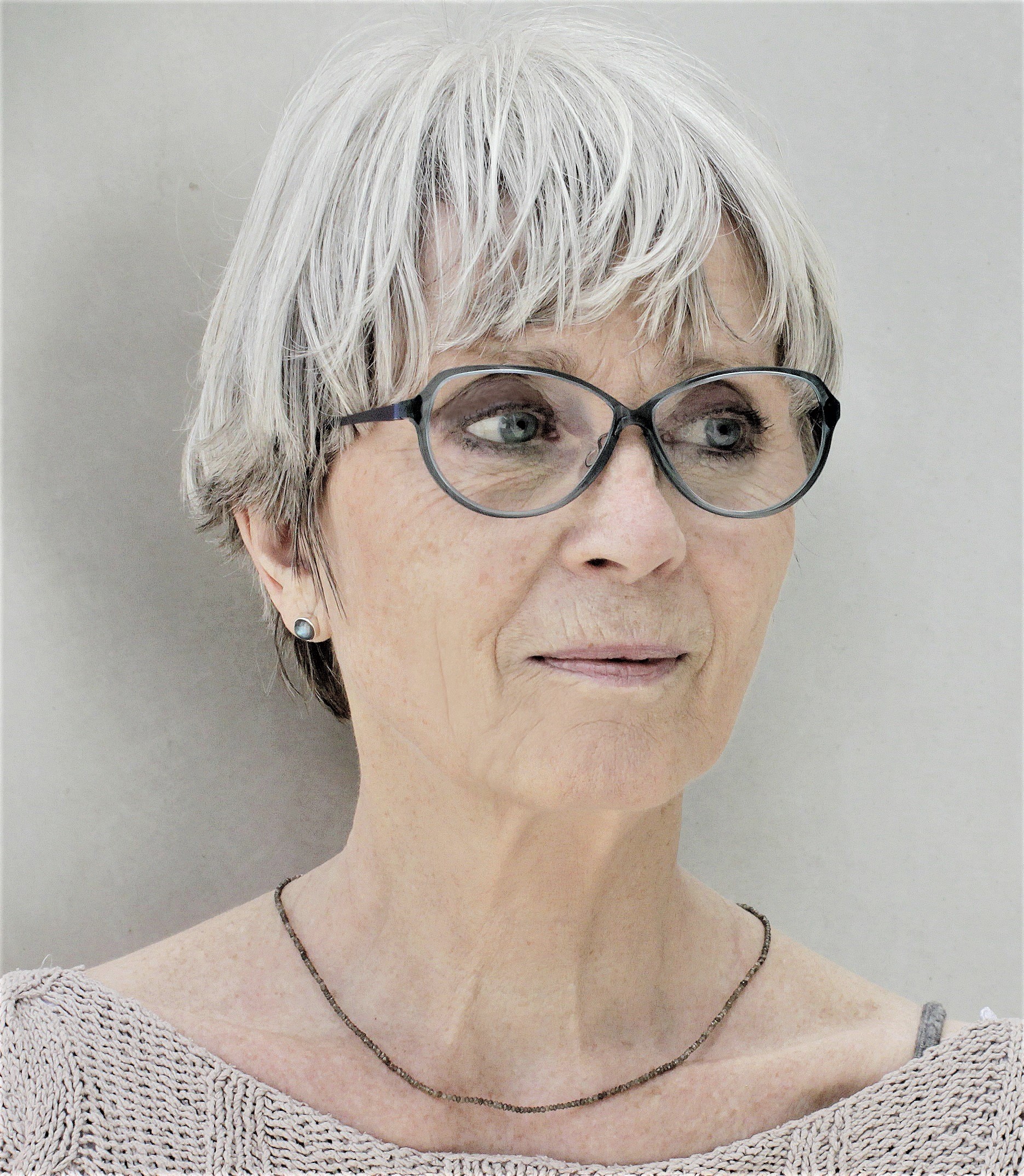 Porträtfoto von Kornelia Boje, kurze graue Haare, Brille und heller Strickpullover