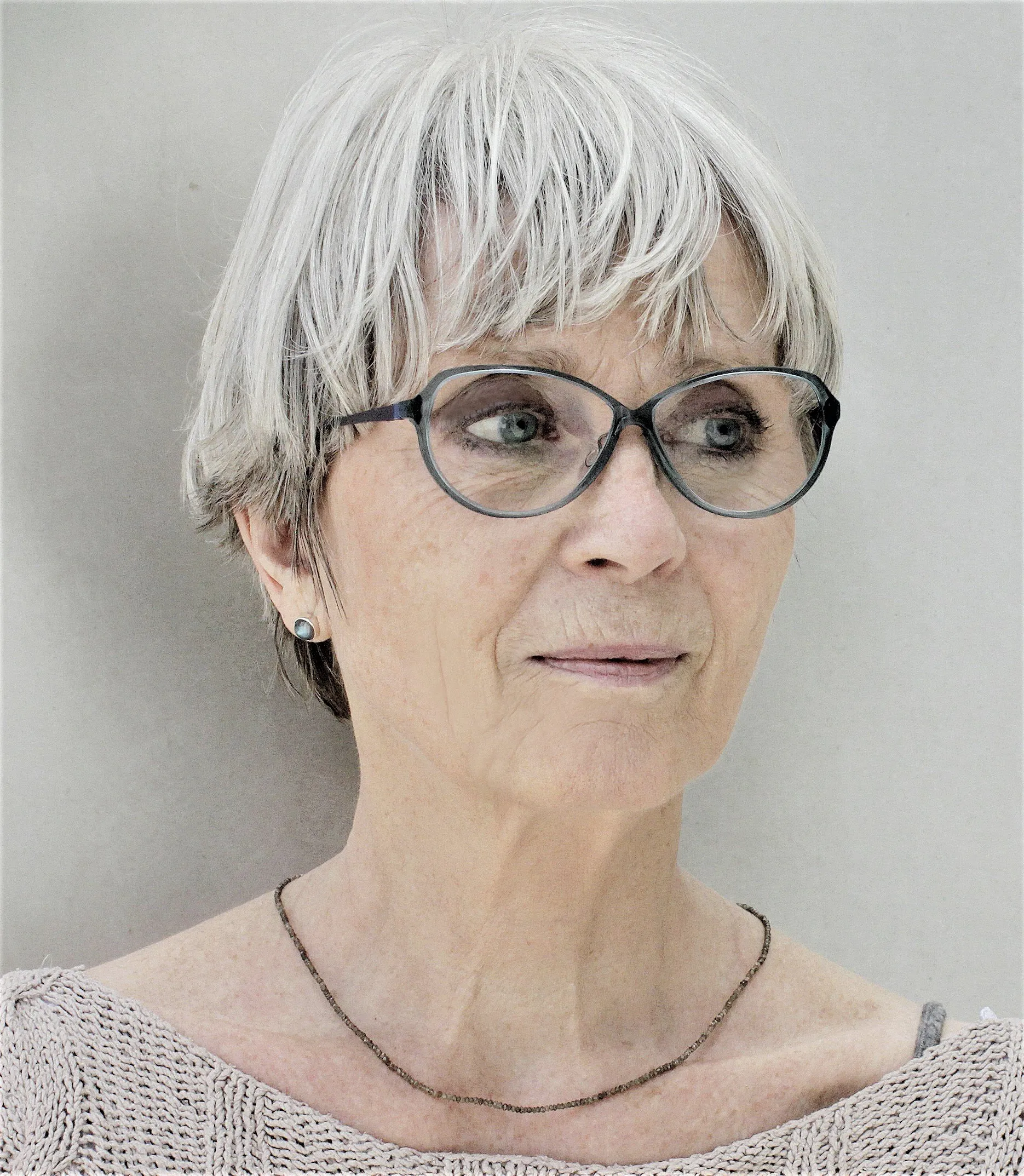 Porträtfoto von Kornelia Boje, kurze graue Haare, Brille und heller Strickpullover