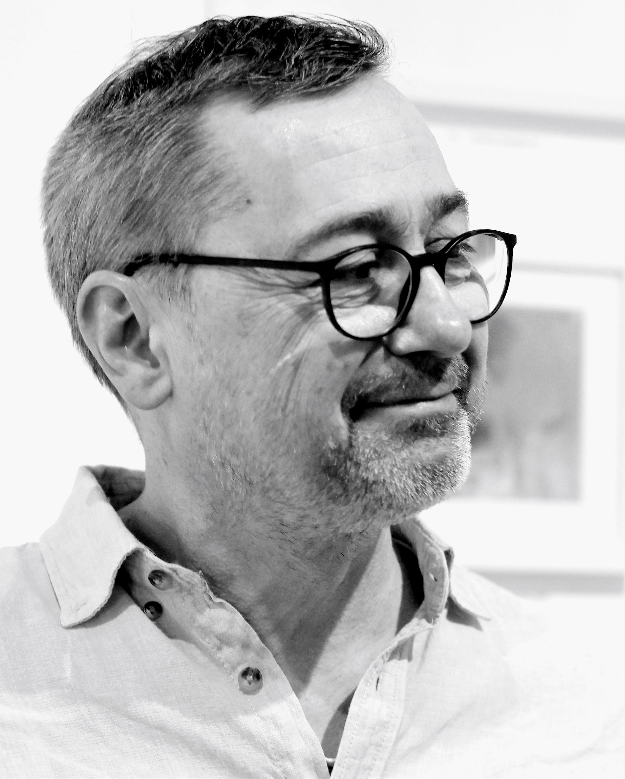 Schwarz-weiß-Porträt von Michael Wäser, er trägt Brille und ein helles Hemd mit offenem Kragen