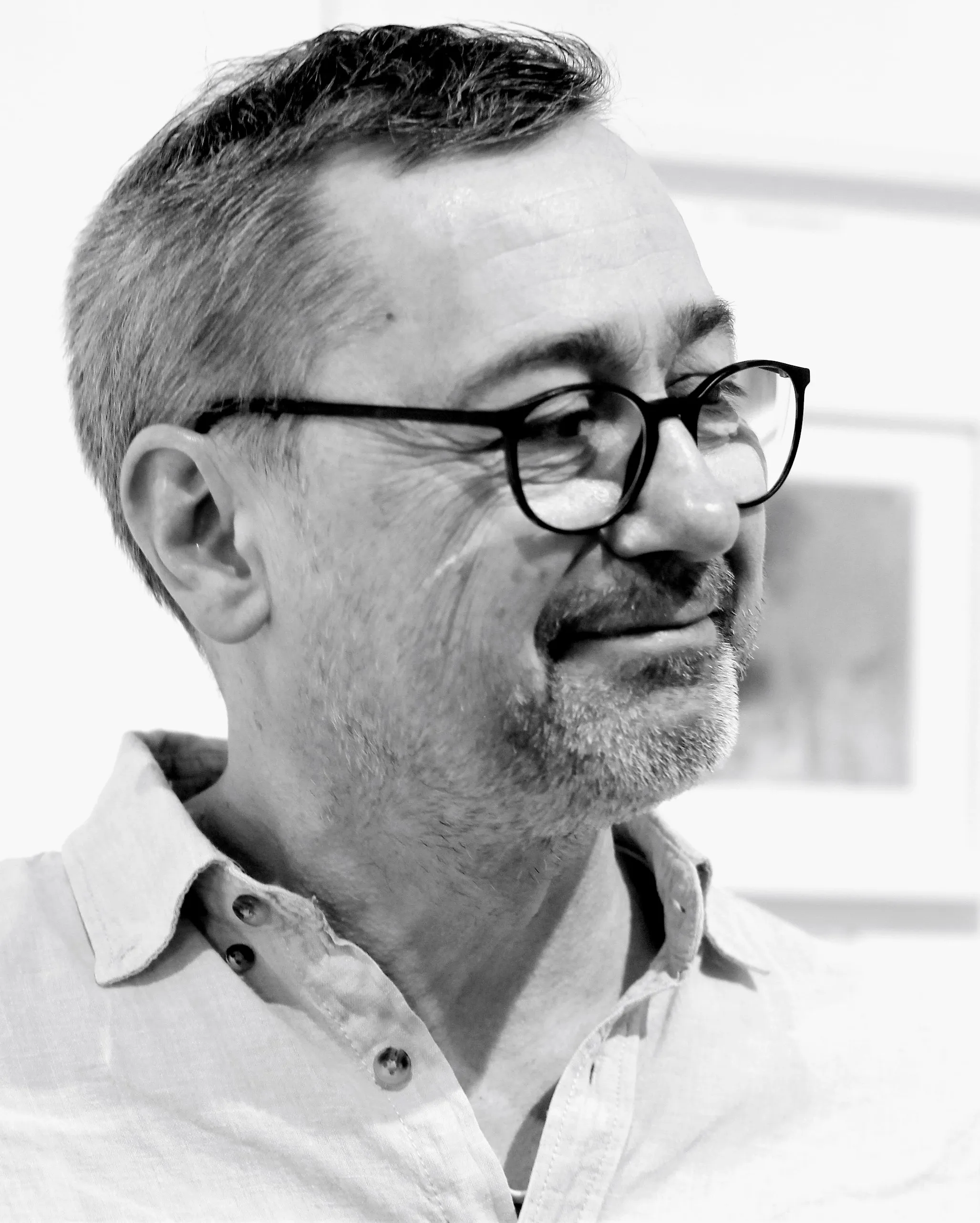 Schwarz-weiß-Porträt von Michael Wäser, er trägt Brille und ein helles Hemd mit offenem Kragen