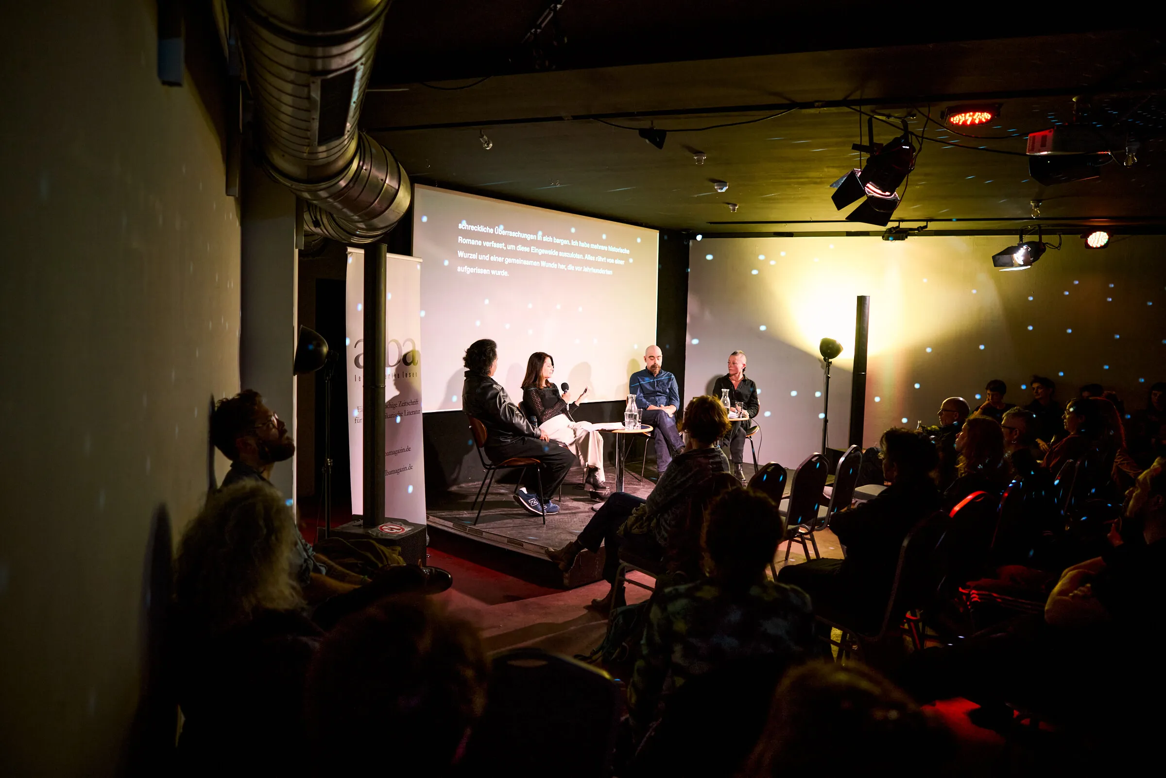 Vier Menschen sitzen auf der Lettrétagebühne