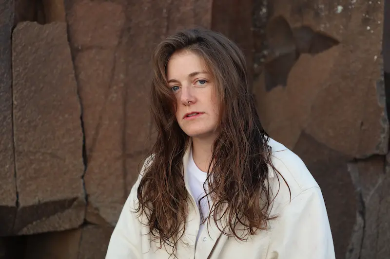 Frau mit langen braunen Haaren und hellem Oberteil