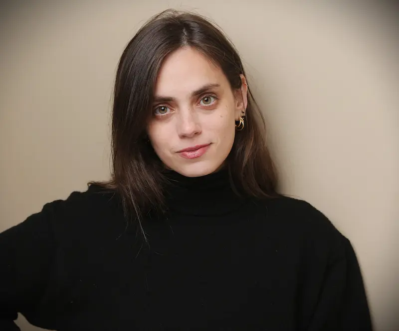 Junge Frau mit glatten braunen Haaren und schwarzem Rollkragenpullover