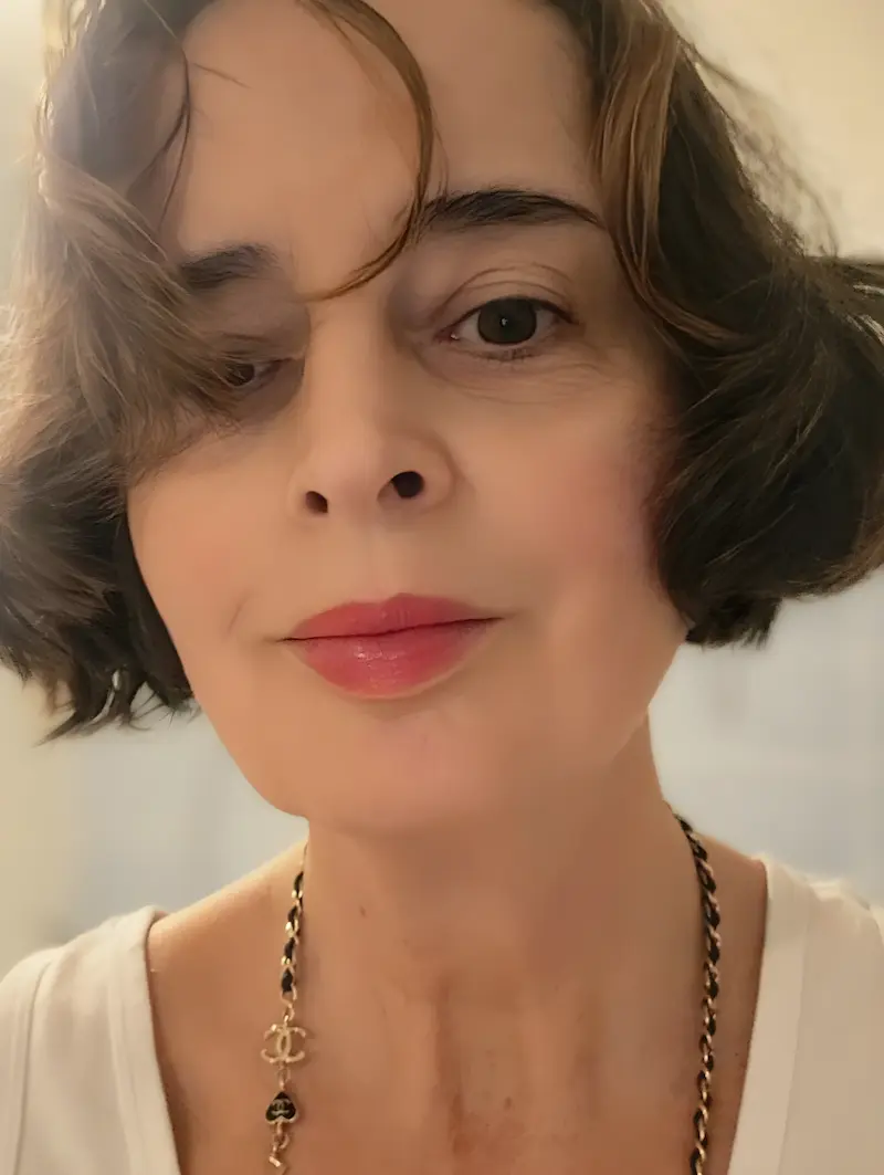 Porträtfoto von Christiane Frohmann, sie hat kurze, braune Haare, trägt einen pinken Lippenstift und eine goldene Kette