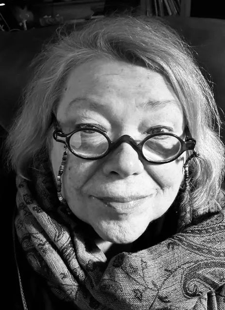 Schwarz-weiß-Porträt von Christina Schuenke, sie trägt eine Brille mit runden Gläsern und einen gemusterten Schal