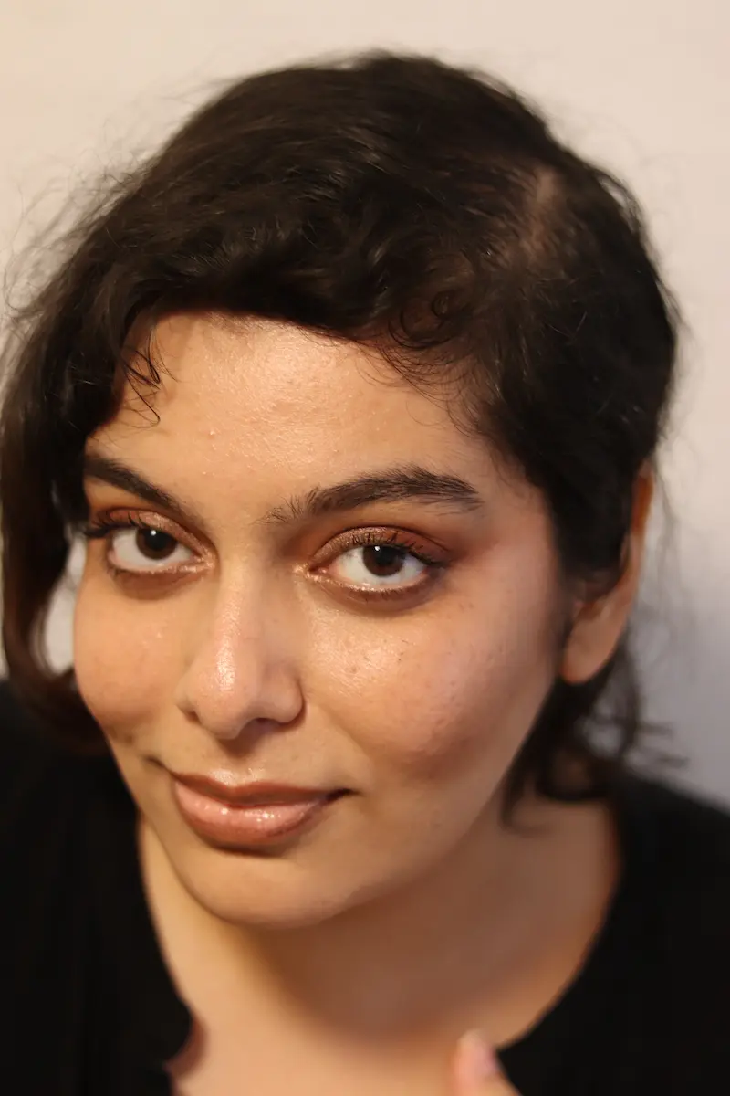 Porträtfoto von Marjan Sareh. Sie lächelt in die Kamera. Ihre langen, dunklen Haare sind zusammengebunden.