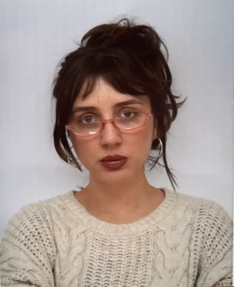Portrait der Künstlerin, trägt weißen Strickpullover, Brille und Hochsteckfrisur