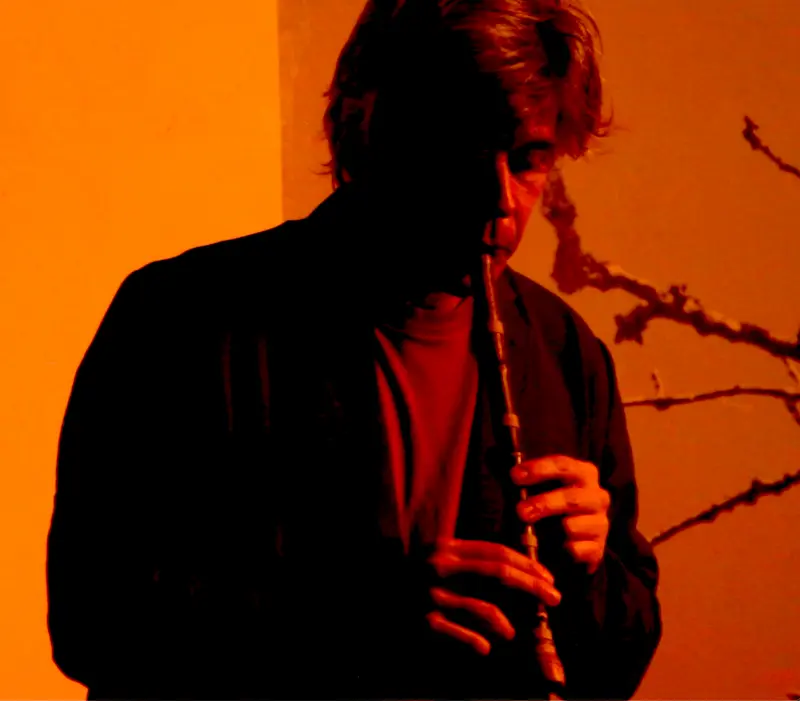 portrait of the artist with orange filter playing a flute
