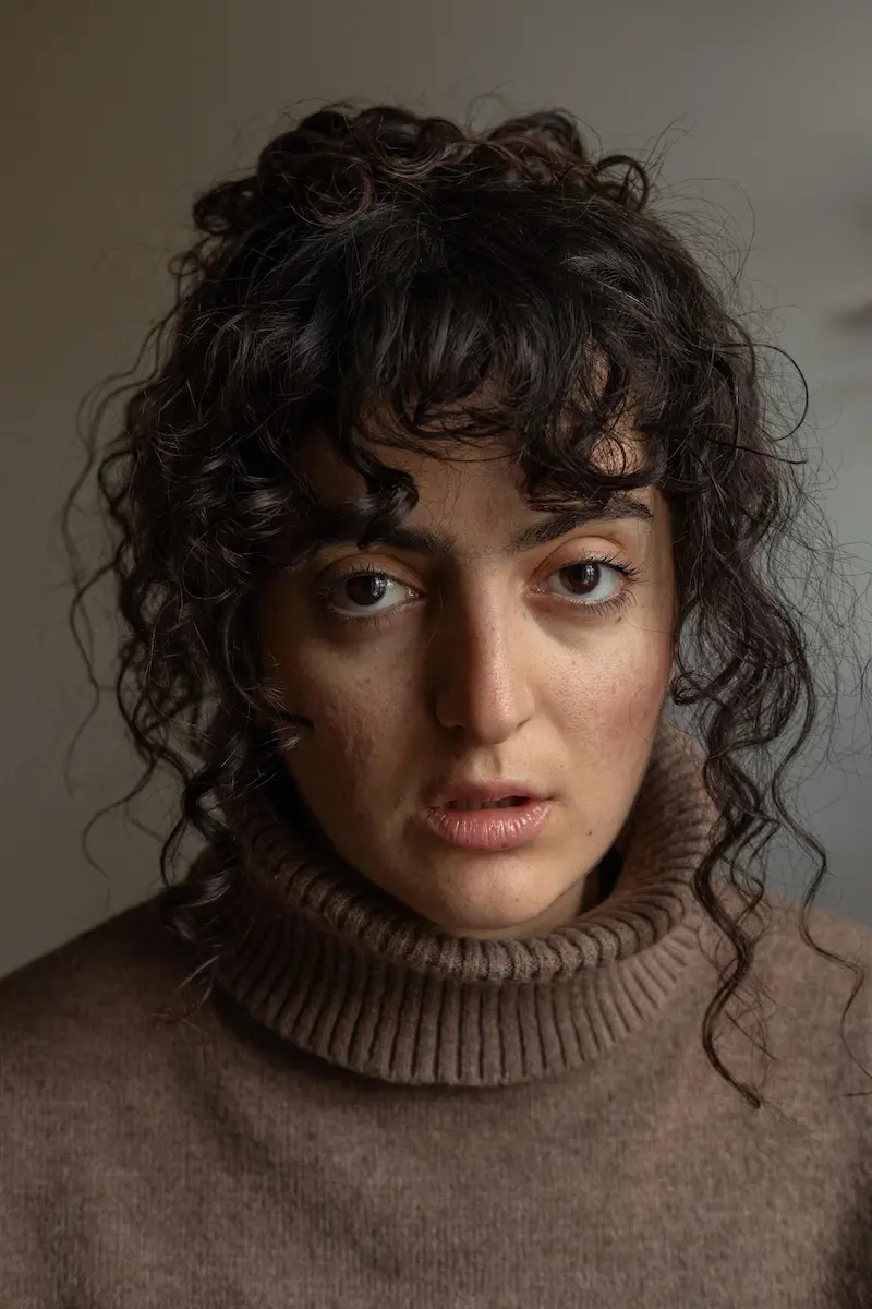 portrait of the artist wearing beige turtle neck