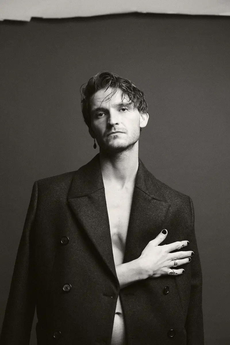 black and white portrait of the artist wearing a black suit jacket