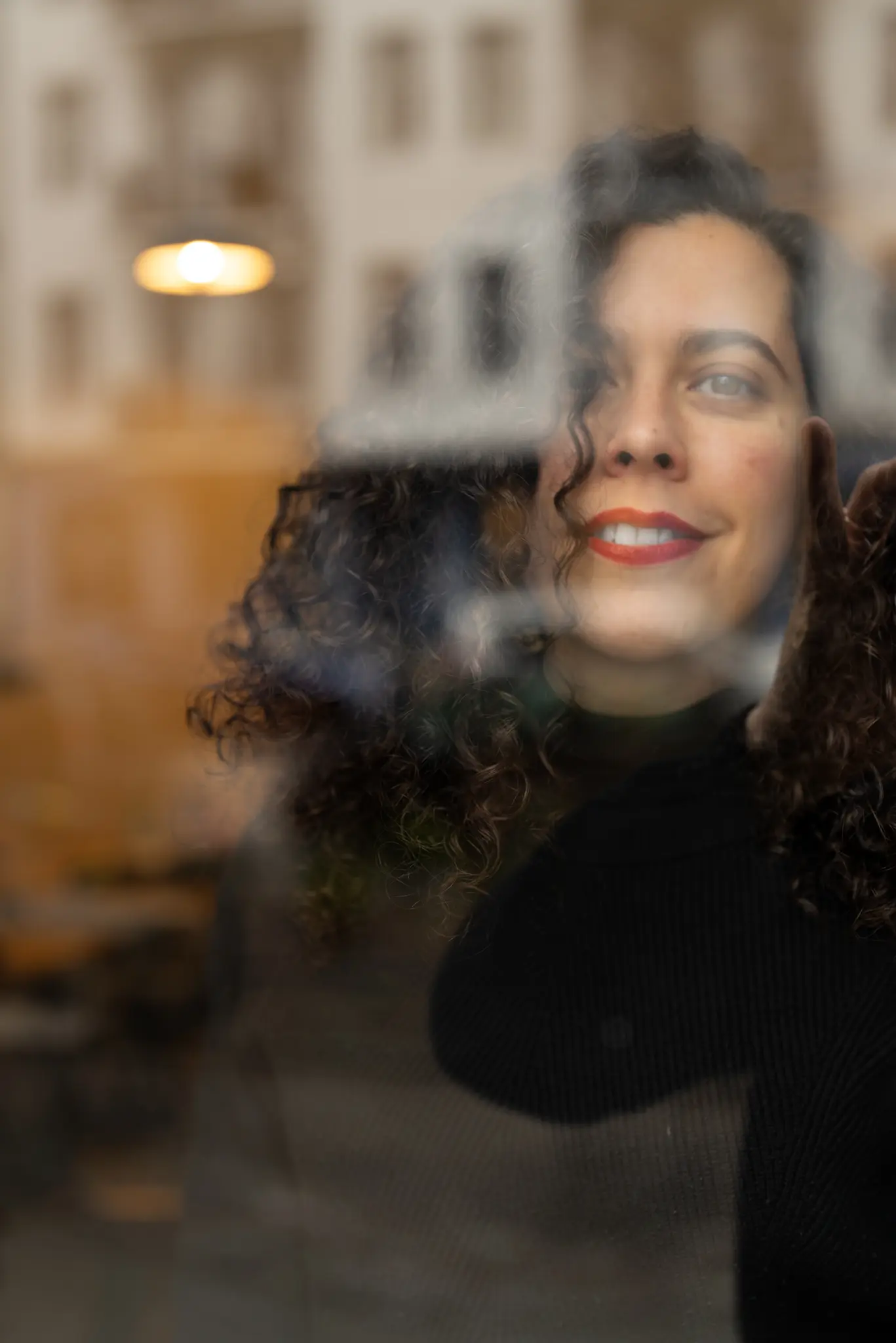 Regina Riveros durch ein spiegelndes Fenster fotografiert
