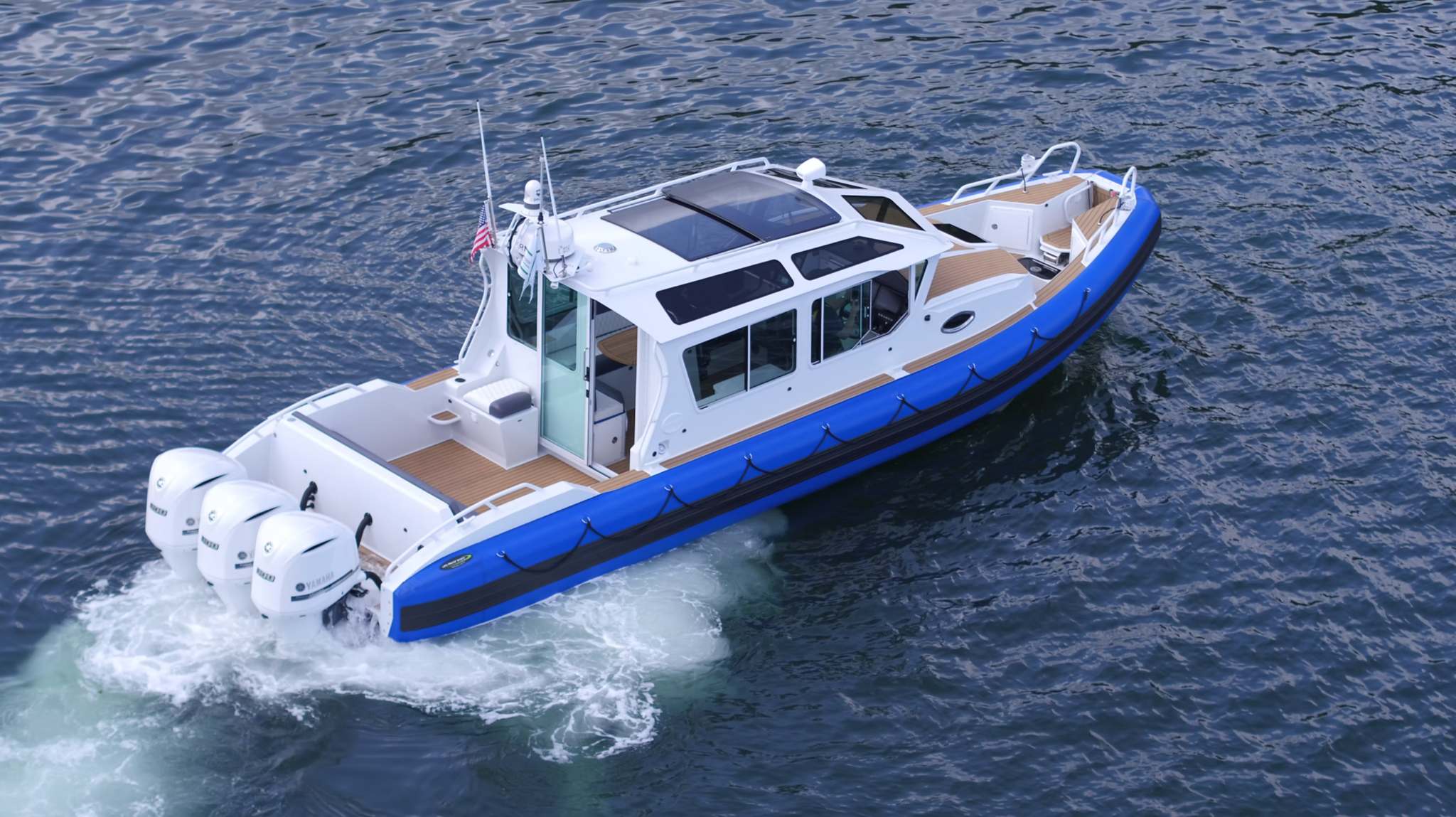 High Speed Hamptons Water Taxi with Yamaha outboard engines cruising on water, viewed from above.