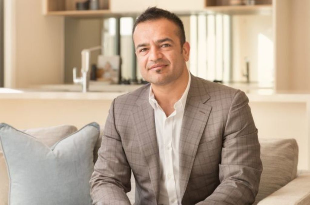 A man in a suite seated in a plush office.