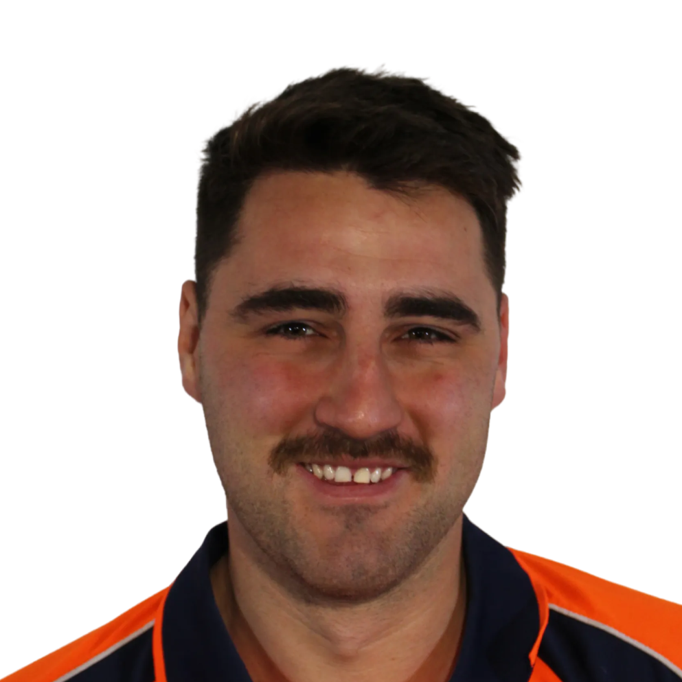 Smiling man with short dark hair and a mustache wearing a navy blue and orange shirt.