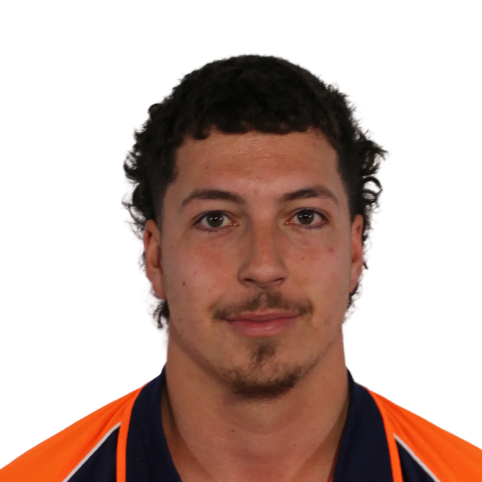 Portrait of a young man with short curly hair, a thin mustache, and goatee wearing a navy and orange shirt.
