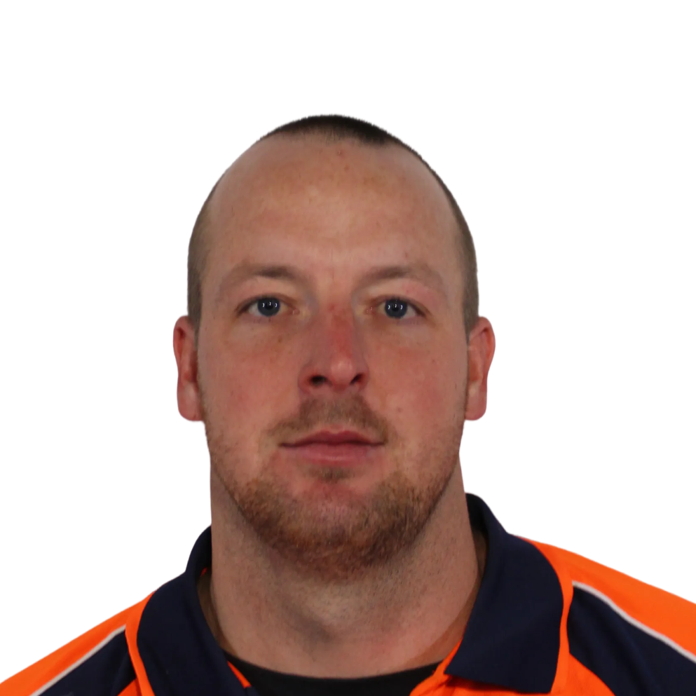 Headshot of a man with short hair and a trimmed beard wearing an orange and navy shirt.