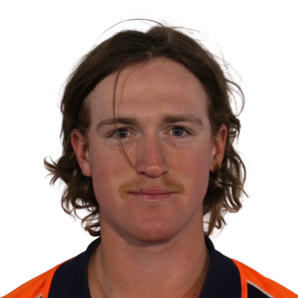 Young man with medium-length brown hair and a light mustache wearing an orange and navy blue collared shirt.