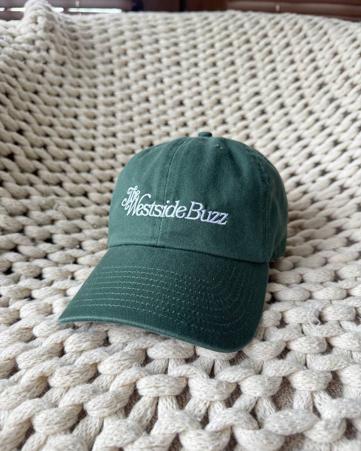 Dark green garment-washed cotton cap with The Westside Buzz script embroidered in white