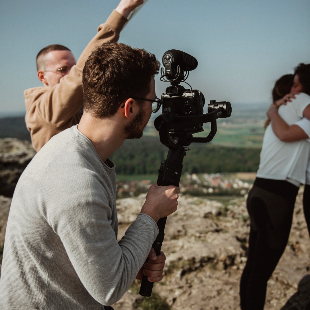 Der Dreh eines Werbevideos von der Werbeagentur Gerngross in Fürth auf einem Berg mit einem Kameramann im Vordergrund