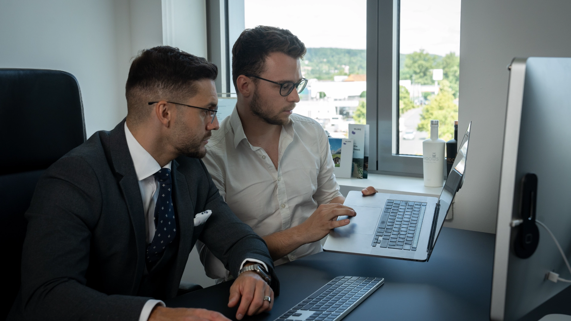 Ein Kundenberatungsgespräch der Werbeagentur Gerngross in Fürth, das Paul Gerngroß und dessen Kunden an einem Schreibtisch zeigt