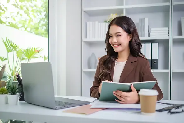 Administrative virtual assistant USA reviewing notes during a remote meeting in a modern home office.