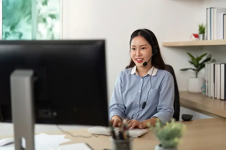 Virtual assistant management specialist offering remote support with a headset and desktop in a home office.