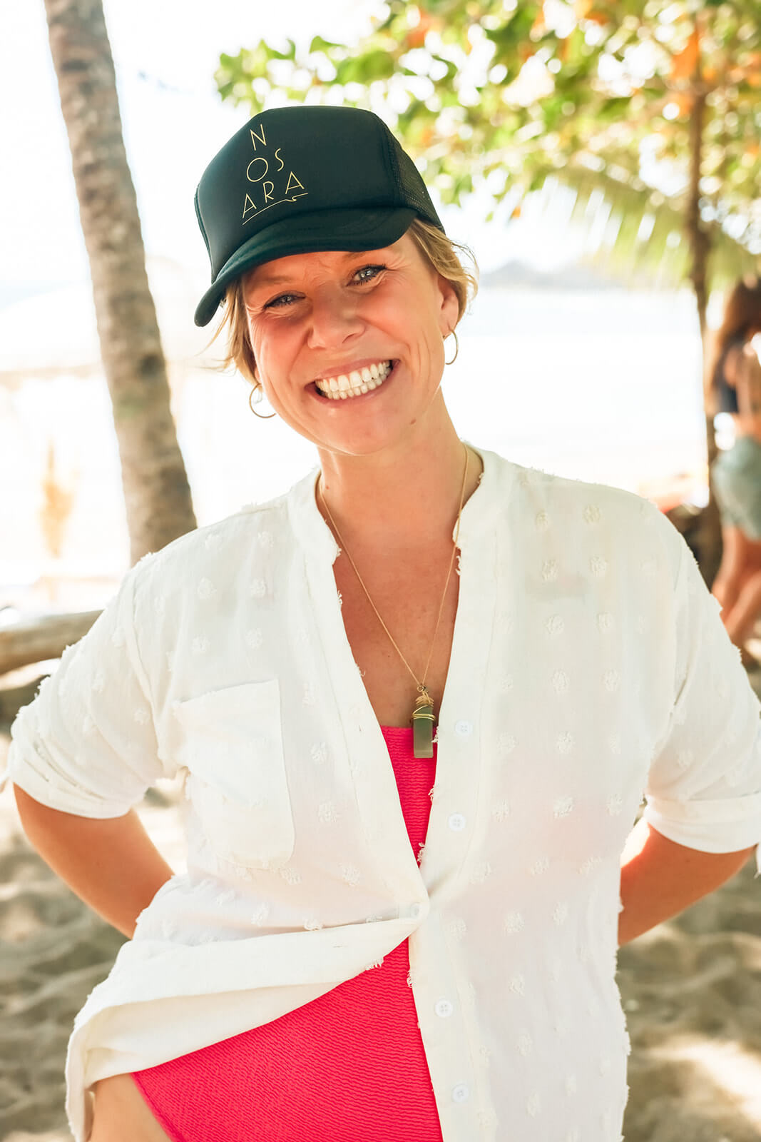 Four people enjoying a boat ride named Buenaventura on calm ocean waters with a forested coastline in the background.