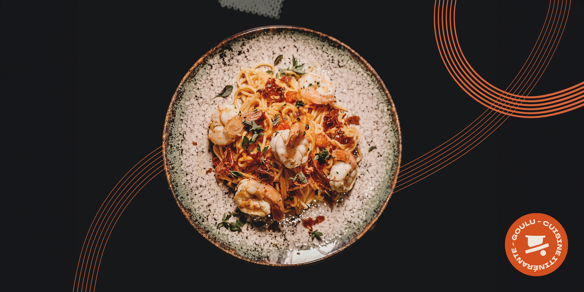Assiette de spaghetti aux crevettes photographiée du dessus, sur fond noir avec éléments graphiques orange Goulu en diagonale.