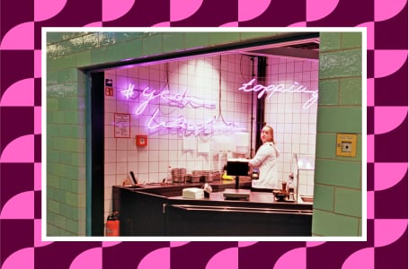 Boutique coffee shop lifestyle avec comptoir, carrelage vert et néon rose, illustrant une identité visuelle mémorable.