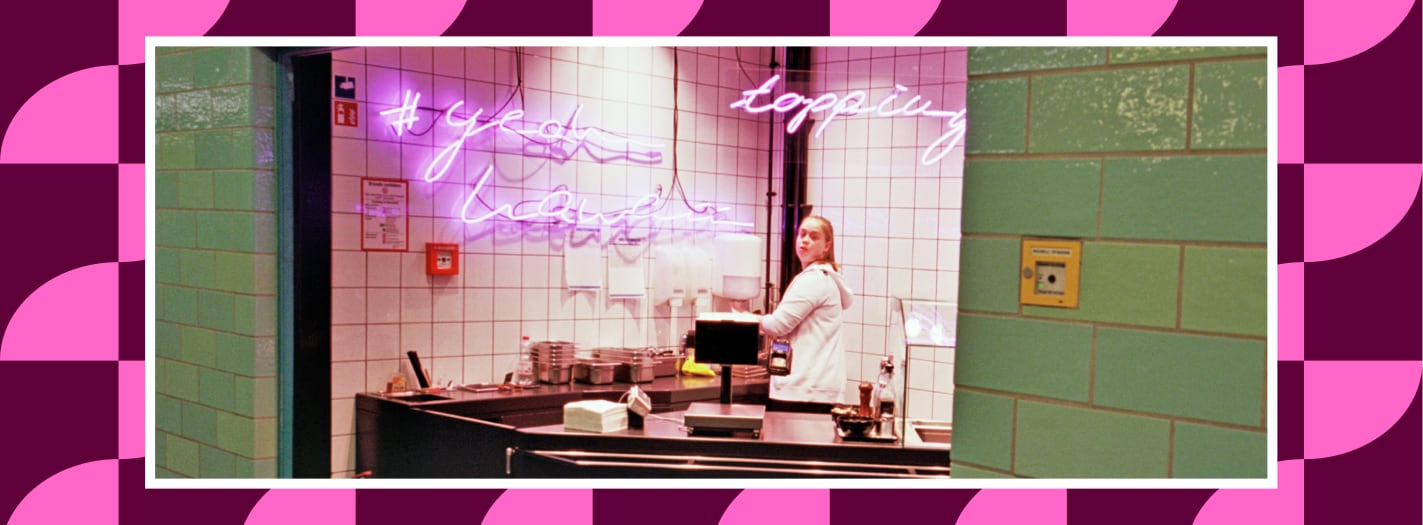 Boutique coffee shop lifestyle avec comptoir, carrelage vert et néon rose, illustrant une identité visuelle mémorable.