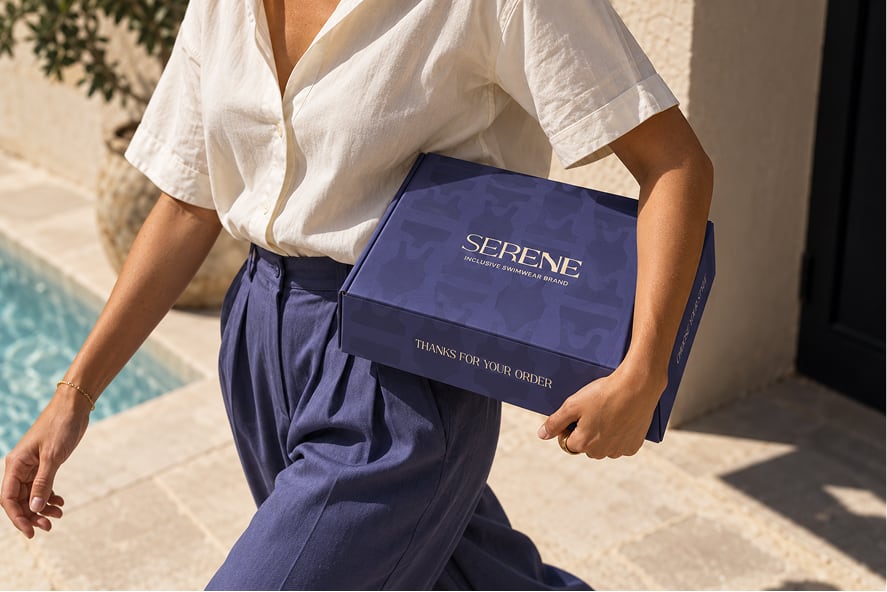 Femme portant une boîte de maillot de bain Serene près d’une piscine