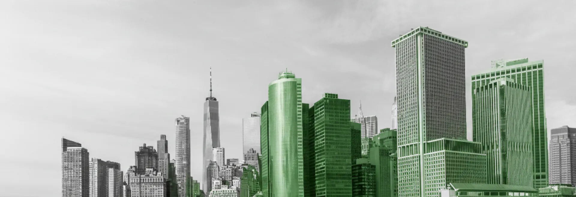 City skyline with tall buildings, some highlighted in green, under a cloudy sky.