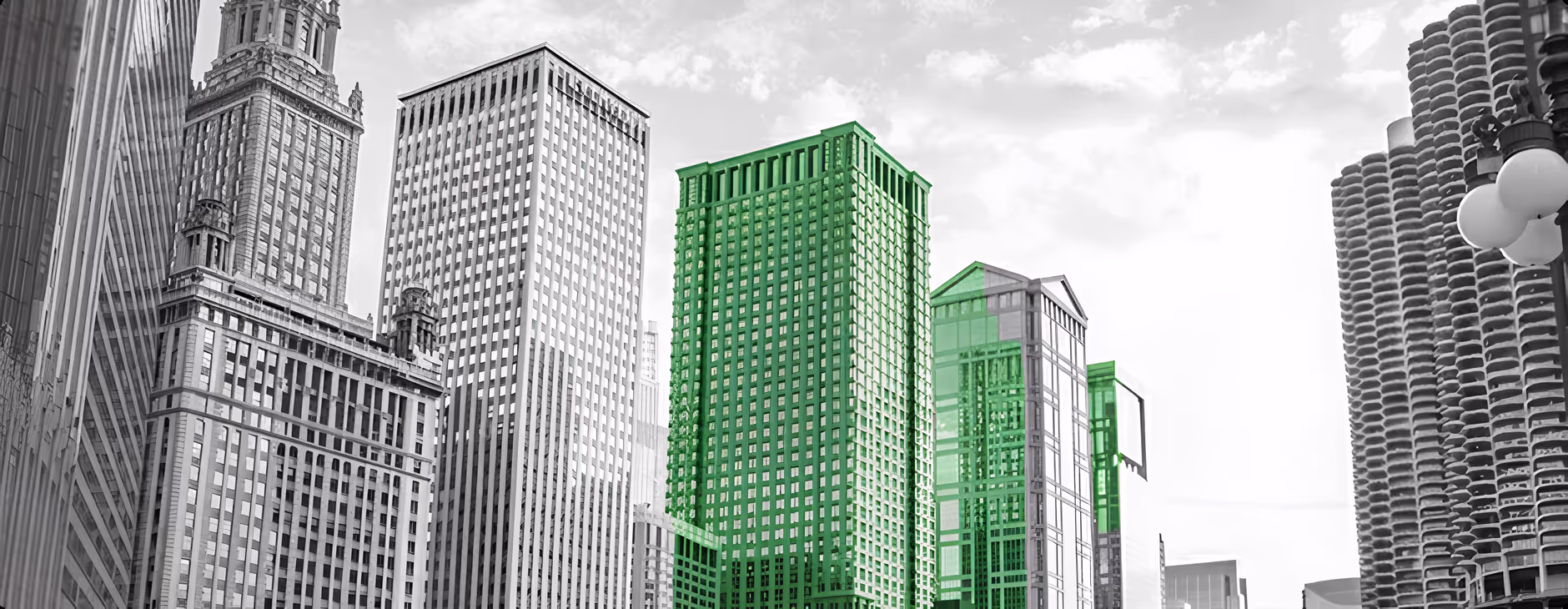 Black and white city skyline with several skyscrapers, some highlighted in green.