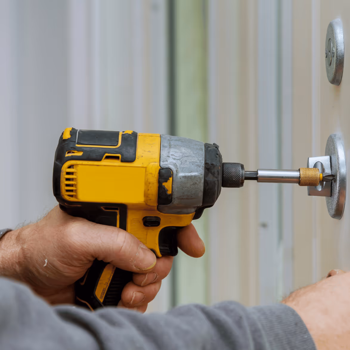 Artisan serrurier réalisant le perçage technique d'un cylindre de haute sécurité à Lille.