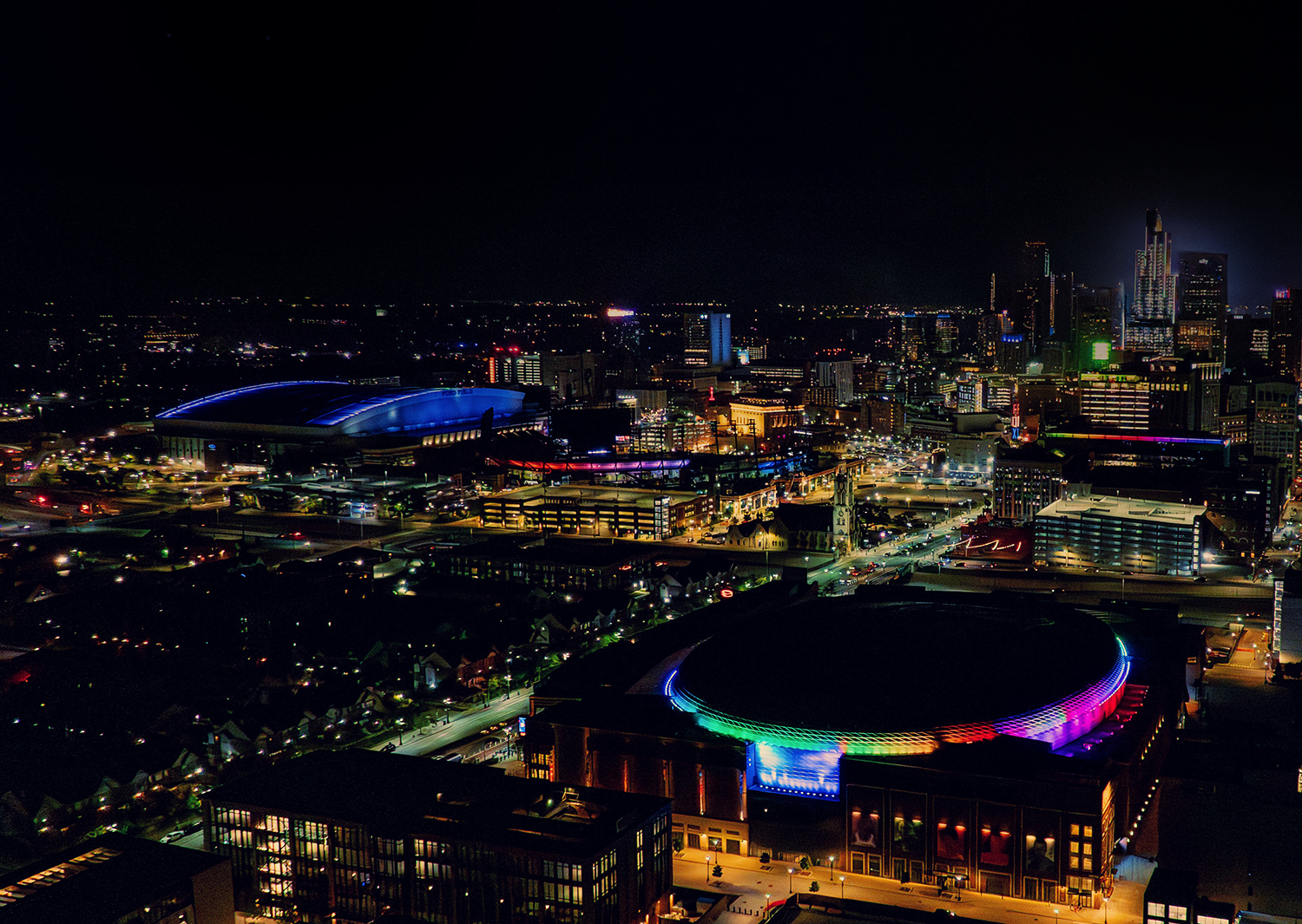 Group of children and adults wearing red Detroit Red Wings hockey attire reaching out to a player walking past them.