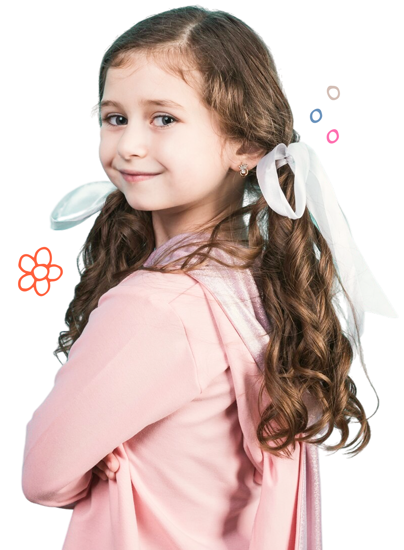 Smiling young girl with long curly hair tied with white ribbons, wearing a pink hoodie and looking over her shoulder.