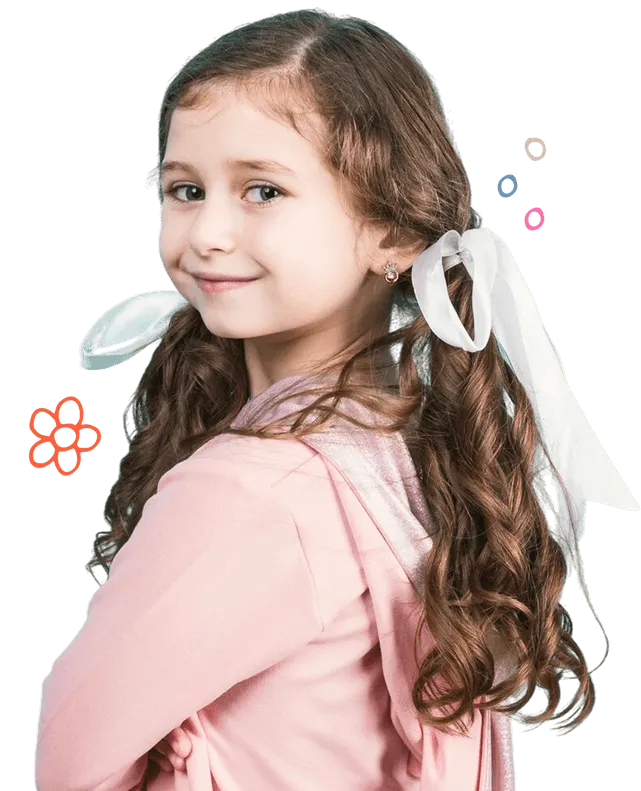 Young girl with long curly hair tied with white ribbons, smiling and wearing a pink hoodie.