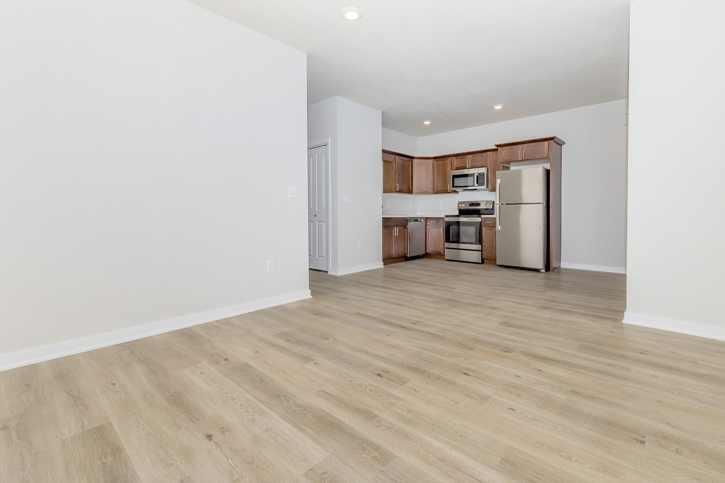 view of living area and kitchen with brown cabinets and stainless steel appliances