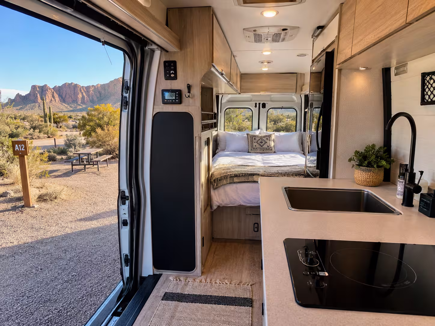 Interior of a camper van rental showing kitchen and bed near Phoenix, Arizona