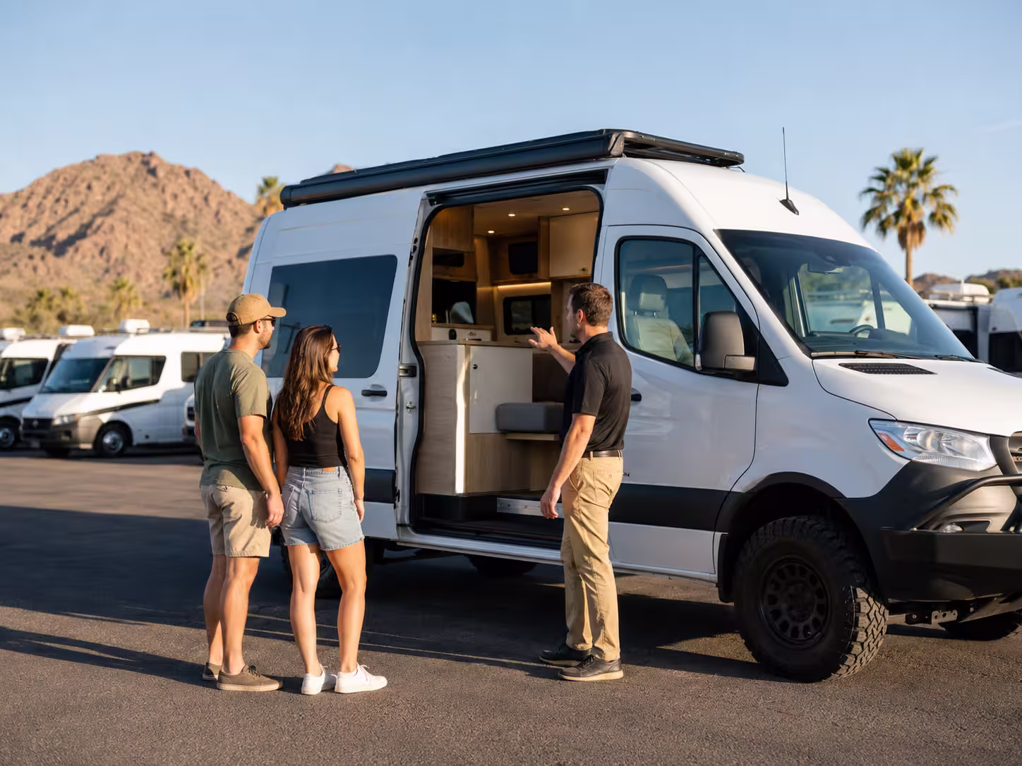 Rental manager showing a camper van to renters in Phoenix, Arizona