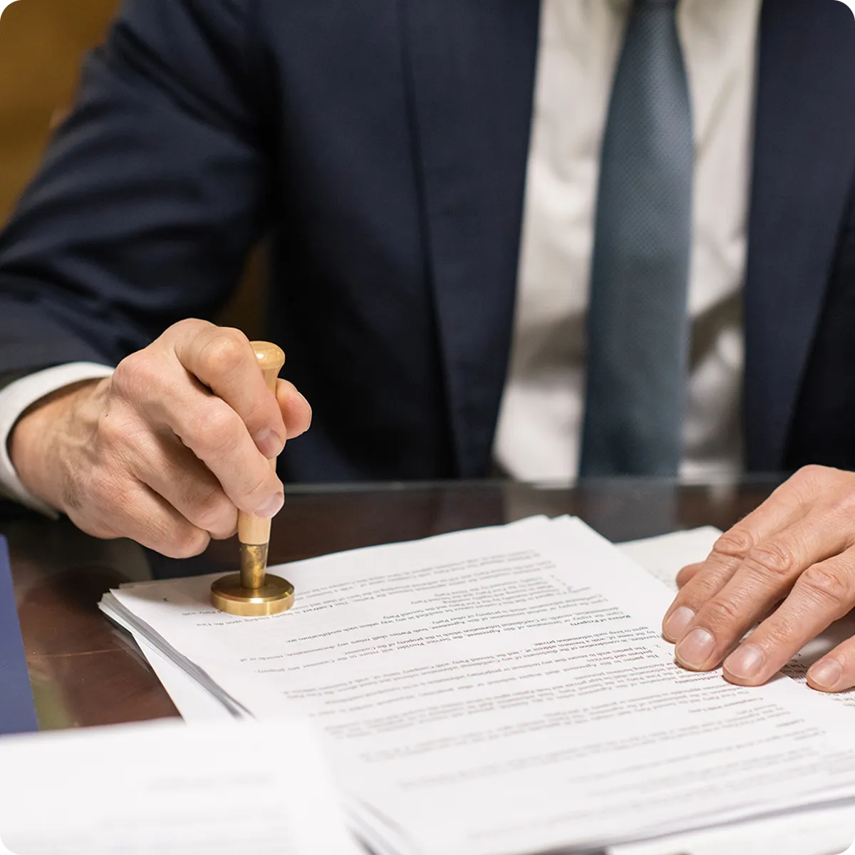 un notario poniendo un sello en unos documentos