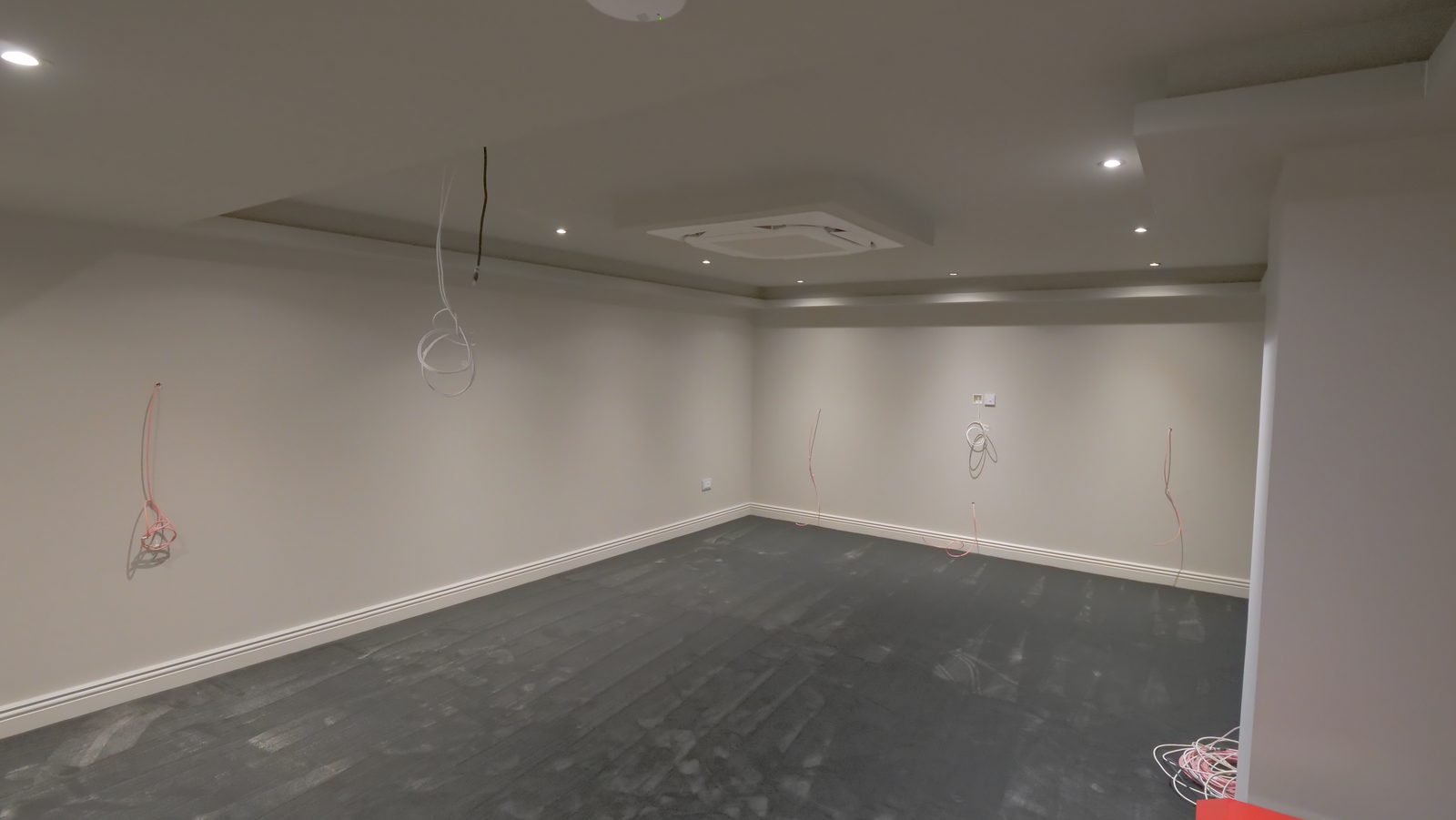 Bare unfinished basement before conversion, opposite angle