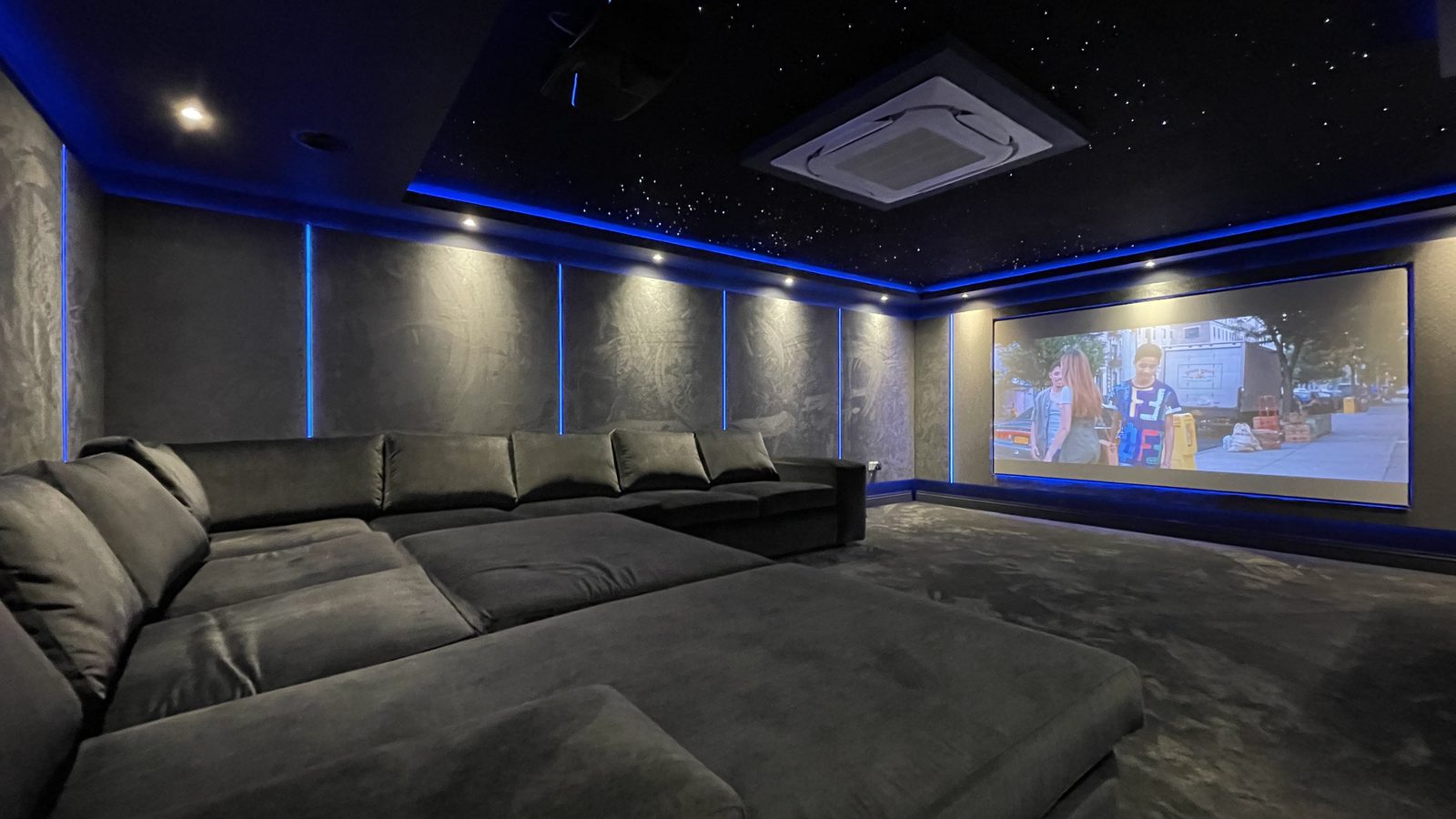 Finished basement home cinema with sectional sofa and star ceiling